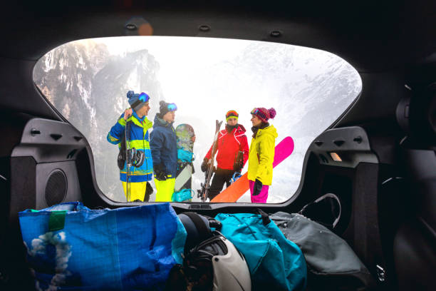 laden das auto nach einem skitag in den bergen - snowboarder in den alpen - gruppe von freunden spaß im winterurlaub - auto packen für den urlaub winter stock-fotos und bilder