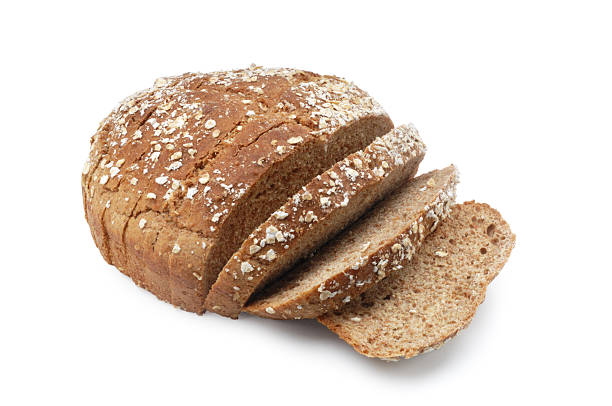 A loaf of brown sesame seed bread with three slices cut Wholemeal, brown, soda bread isolated on white. 7 grain bread photos stock pictures, royalty-free photos & images