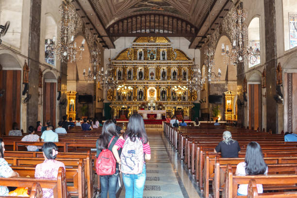 creyentes filipinos locales y visitantes en la basílica de santo niño de cebú - ni��o fotografías e imágenes de stock