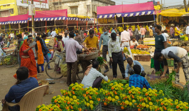 Local new market crowd on the eve of Diwali and Chhath puja. Flower shopkeeper chatting with his customer. People selling & purchasing festival and worship materials. Buying pomegranate from cycle shop. Katihar,Bihar/India-20/11/2020; Local new market crowd on the eve of Diwali and Chhath puja. Flower shopkeeper chatting with his customer. People selling & purchasing festival and worship materials. Buying pomegranate from cycle shop. (Sweets, fruits, flowers, vegetables) chhath stock pictures, royalty-free photos & images