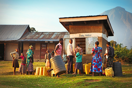 Nyarusiza, Uganda - May 28, 2017: Local villagers waiting with plastic canisters to get safe water from public water well