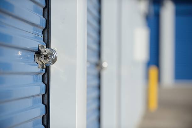 Locked self storage unit. Lock on a self storage unit door. Shallow DOF. self storage stock pictures, royalty-free photos & images