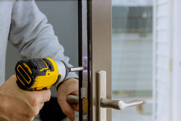 Locksmith hand holds the screwdriver in installing new house door lock Locksmith in installing new house door lock hand holds the screwdriver locksmith stock pictures, royalty-free photos & images