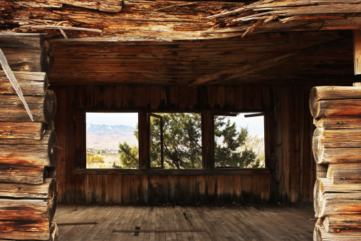 The view through an abandoned log cabin doorway and out through its windows to the desert landscape beyond.  Cottonwood, Arizona, 2013.