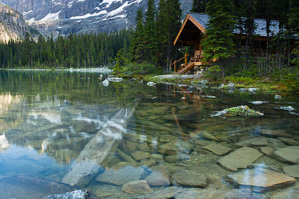 Evening shot of a cabin at Lake O'Hara, BC, Canada. Rocks are seen beneath the water surface.