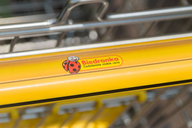 logo of biedronka on shopping cart. biedronka is one of the largest chain supermarkets in poland. - biedronka imagens e fotografias de stock