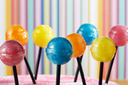 A close up of different colored lollipops on sticks