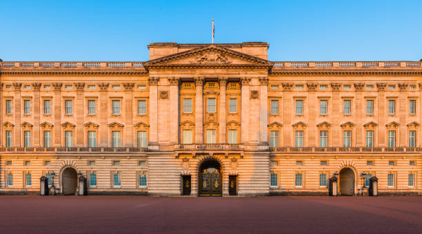 London Buckingham Palace ornate facade illuminated at sunrise panorama UK stock photo
