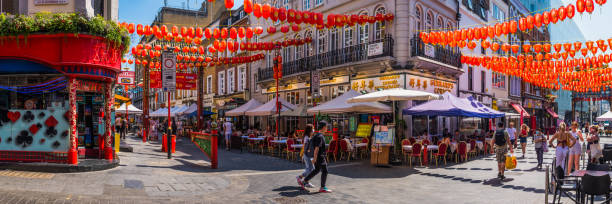 London Chinatown paper lanterns over busy restaurant streets summer panorama stock photo
