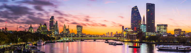 The iconic dome of St. Paul’s Cathedral, the glittering spires of the City skyscrapers and the futuristic towers of the South Bank overlooking the River Thames illuminated before sunrise in the heart of London, the UK’s vibrant capital city.