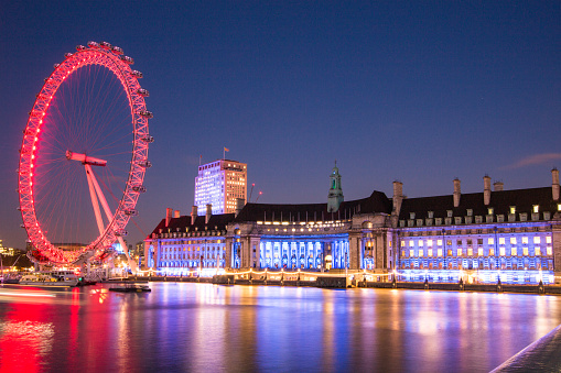 The Coca-Cola London Eye and London Aquarium at Night, illuminated and reflecting onto the River Thames