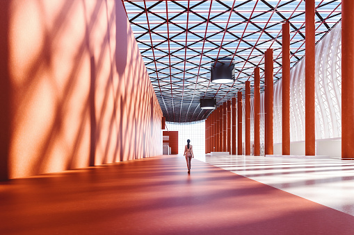 Lone businesswoman walking in empty exhibition hall, 3D generated image.
