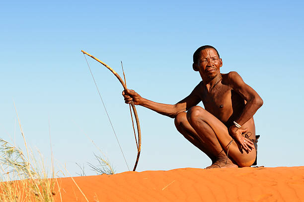 Lone Kalahari bushman on red sand dune stock photo