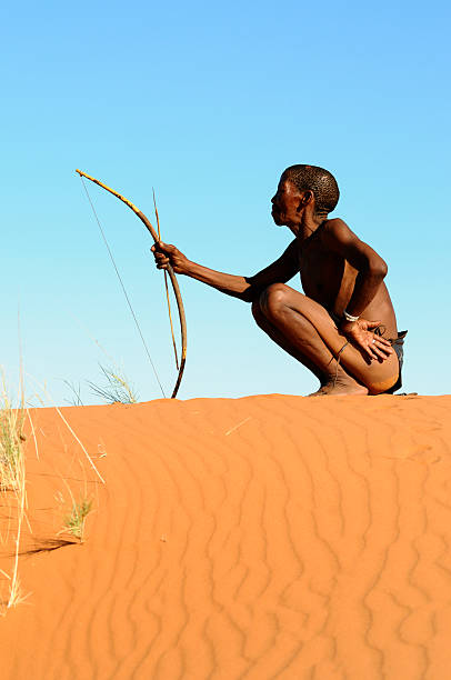 Lone Kalahari bushman on red sand dune portrait stock photo