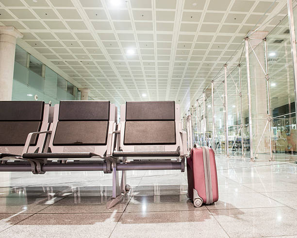 lone suitcase in waiting area stock photo