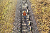 istock Loneliness concept. A man walks along the railway tracks, running away from himself. 1355528622