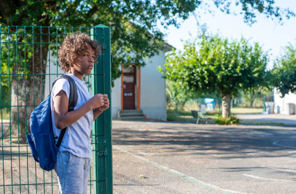 lonely boy at schoolyard stock photo