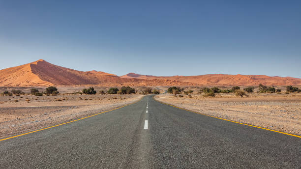 Lonely Empty Desert Road through Sossusvlei Desert Landscape Namibia stock photo