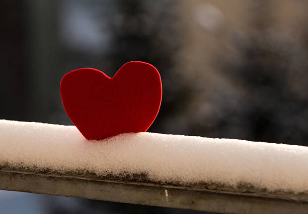 Lonely heart on snowy railing stock photo