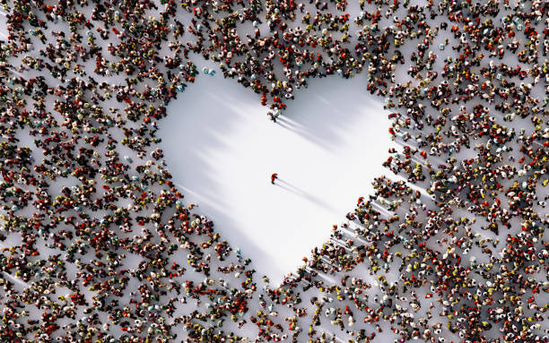 Lonely man in the middle of a white heart shaped void surrounded by people on white background. Horizontal composition with copy space. Loneliness concept.