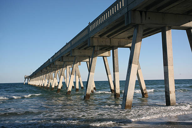 long concrete pier at beach stock photo