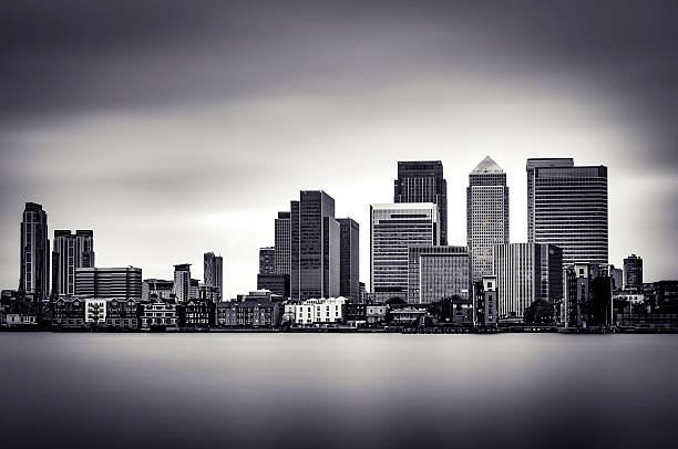 B&W, long exposure, atmospheric image of Canary Wharf Black and White panoramic view of Canary Wharf, the financial district in London, England, UK canary wharf stock pictures, royalty-free photos & images