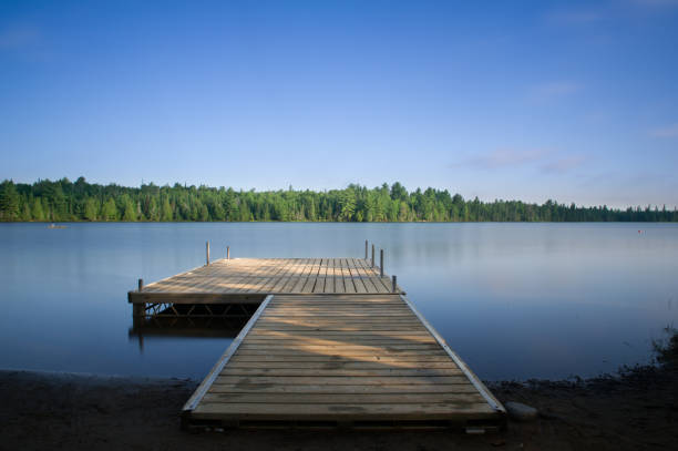 Long exposure shot of a wooden dock on silky lake stock photo