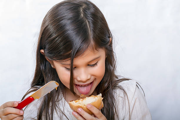Long haired girl tries to prove bread slathered stock photo