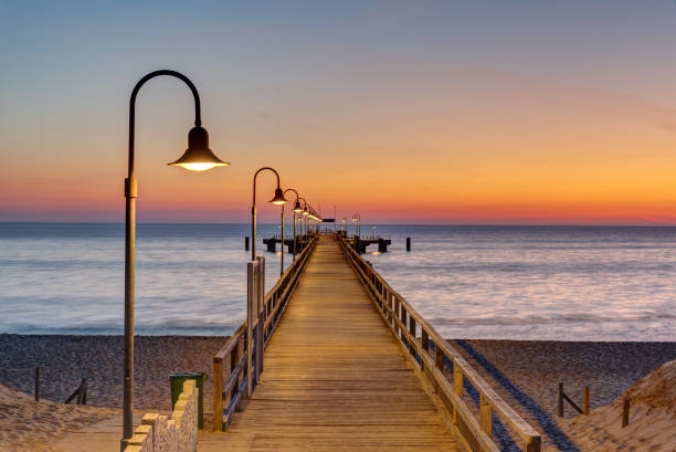 Long pier at the german baltic sea coast Long pier at the german baltic sea coast before sunrise sellin stock pictures, royalty-free photos & images