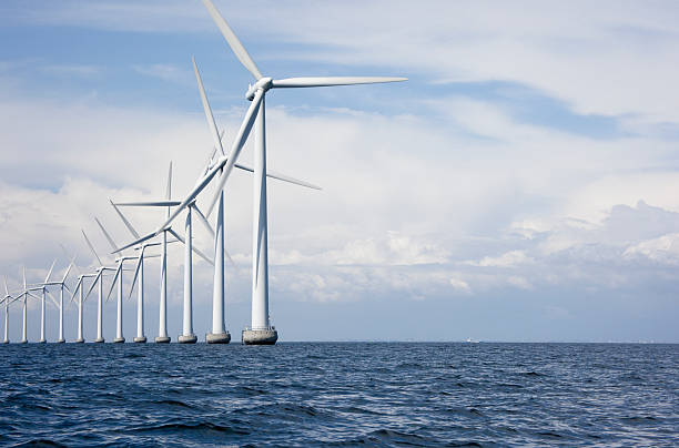 Long row a very tall windmills offshore stock photo