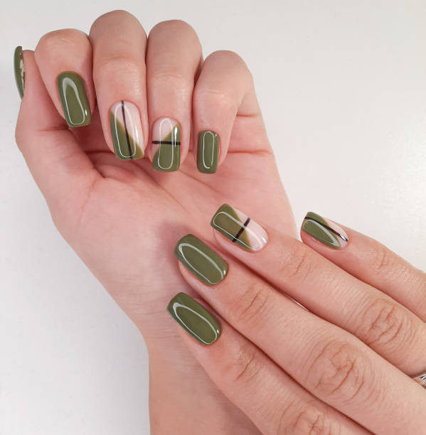 Long square nails with swamp-green gel polish. Green manicure with geometric design of black stripes. Long square nails with swamp-green gel polish. Green manicure with geometric design of black stripes. gel nail polish stock pictures, royalty-free photos & images