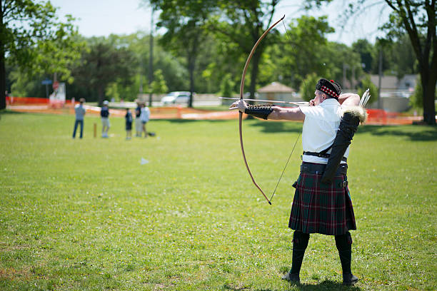 Longbow Archer "Milwaukee, USA - June 2, 2012: A reenactor demonstrates use of the longbow at the Milwaukee Highland Games." milwaukee shooting stock pictures, royalty-free photos & images