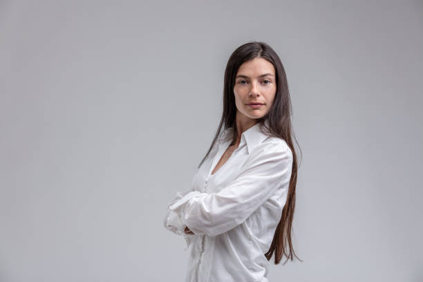 Long-haired brunette woman with arms crossed Portrait of long-haired brunette woman standing with arms crossed snob stock pictures, royalty-free photos & images