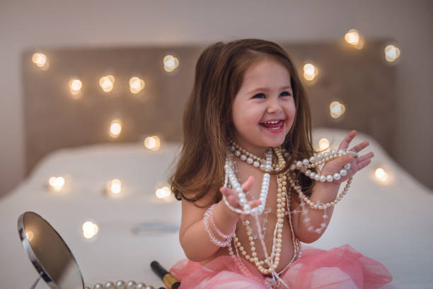 Look I'm all grown up two and a half year old girl wants to be like her mother , so she is using mother jewelry and make up beauty pageant stock pictures, royalty-free photos & images