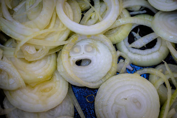 Looking Down on Chopped Onions, with a Face Visible in One of the Slices stock photo