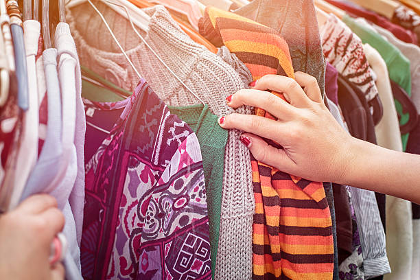 looking on a flea market for clothes close up of a hand, looking on a flea market for clothes. clothes rack stock pictures, royalty-free photos & images
