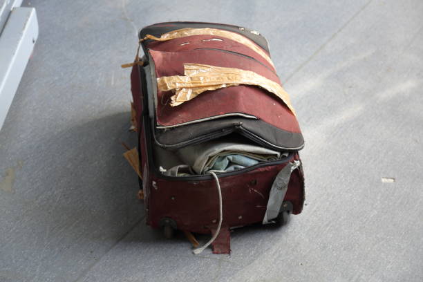 Lost baggage at the airport Old torn suitcase with things on the floor of the airport broken suitcase stock pictures, royalty-free photos & images