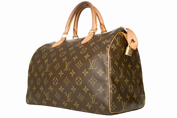 Louis Vuitton handbag "Truro, MA USA - October 3, 2012. A Louis Vuitton handbag isolated on white. Louis Vuitton is also called LVMH and has the famous LV monogram. LVMH's headquarter is in Paris, France." bringing home the bacon stock pictures, royalty-free photos & images