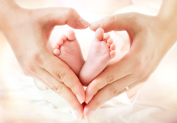 love and childhood - newborn feet in mom hands baby feet in mother hands - hearth shape allemagne foot stock pictures, royalty-free photos & images