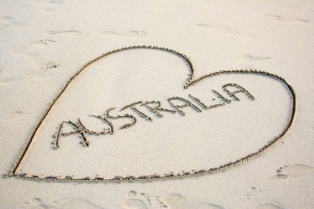 Love heart drawn in beach sand with Australia written inside it.