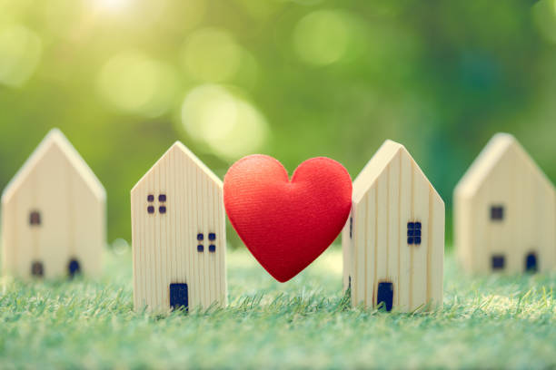 Love heart between two house wood model for stay at home for healthy community together on green fresh ecology natural environment. stock photo