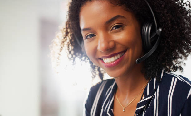 I love helping people Cropped portrait of an attractive young businesswoman wearing a headset while in the office during the day headset woman customer service stock pictures, royalty-free photos & images