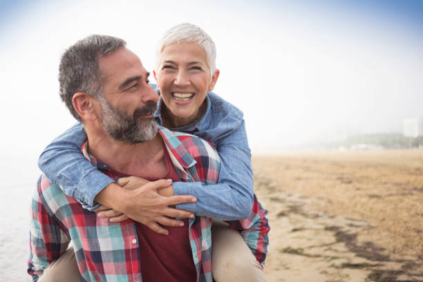 Love is always playful Mature playful couple at beach mature couple stock pictures, royalty-free photos & images