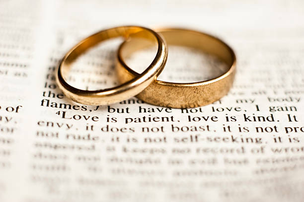 Love is patient Wedding rings sitting on the 1 Corinthians 13 Bible passage on what love is. wedding ring stock pictures, royalty-free photos & images