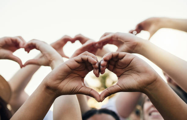 Love more, hate less Cropped shot of a group of unrecognizable people forming a hearts with their hands heart image stock pictures, royalty-free photos & images