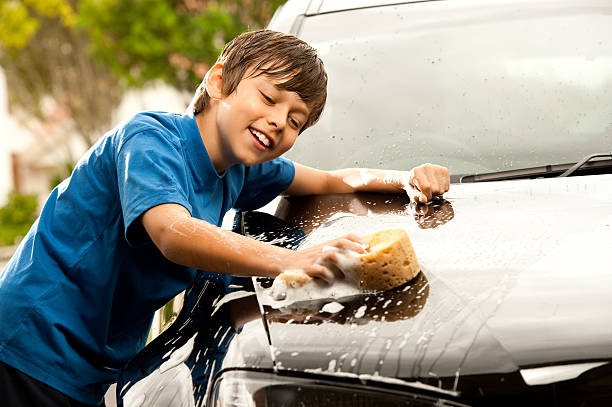 I love washing Dads car! Cute boy washing a car on a hot summers day. allowance stock pictures, royalty-free photos & images