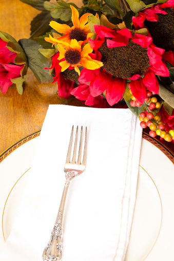 Lovely autumn place setting on oak table.  Fall flowers centerpiece.
