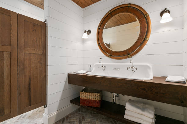 Lovely bathroom with open storage shelves Round mirror and sconce lights on a shiplap wall in bathroom shiplap stock pictures, royalty-free photos & images