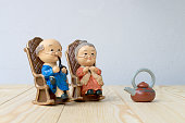 立地の背景を持つ木製のテーブルで一緒に古いソファチェア古典的な素敵な祖父母の人形。