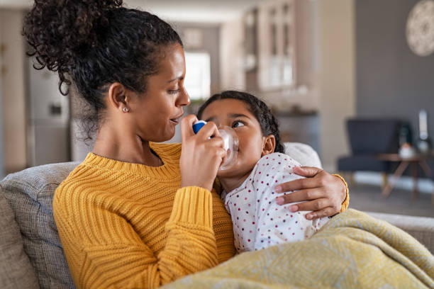 härlig mor omfamna dotter gör inandning med en nebulisator - luftvägsinfektion bildbanksfoton och bilder